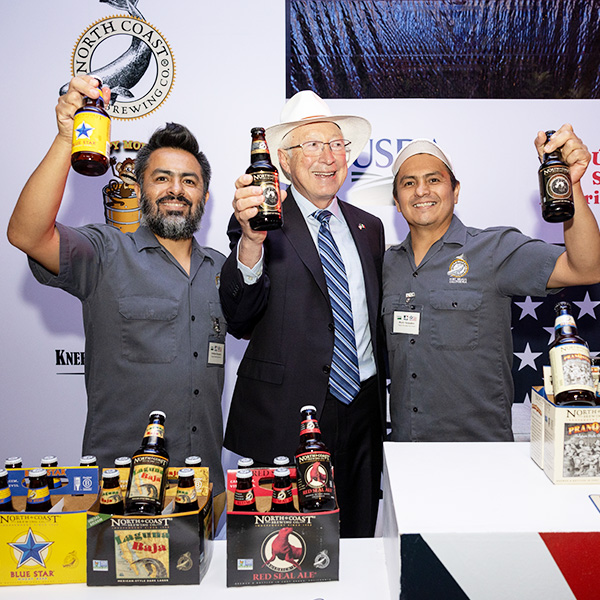 3 men posing with beer at pregame event in Mexico