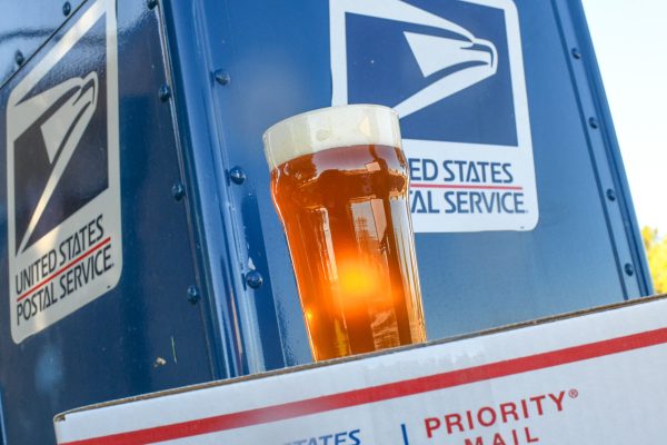glass of beer near a USPS collection box