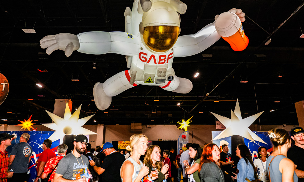 inflatable space explorer suspended above crowd at beer festival