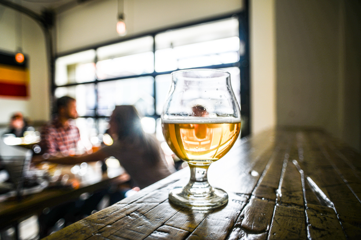 snifter in a brewery with people in the background